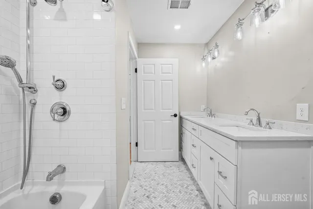 a bathroom with a double vanity sink mirror and shower