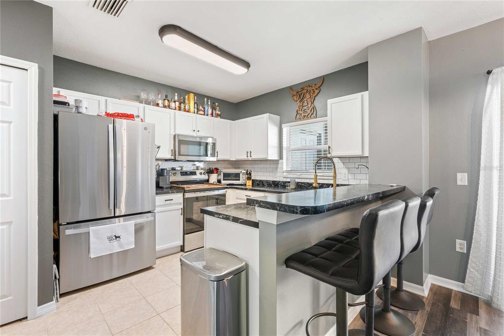 1533 Blue Magnolia Road Brandon, FL 33510 - Photo 11 of 41 a kitchen with stainless steel appliances granite countertop a refrigerator and a stove top oven