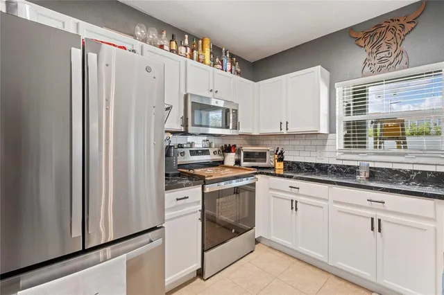 a kitchen with granite countertop cabinets stainless steel appliances and a sink