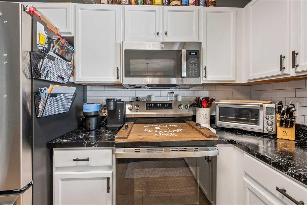1533 Blue Magnolia Road Brandon, FL 33510 - Photo 17 of 41 a kitchen with stainless steel appliances granite countertop a stove a sink and a microwave
