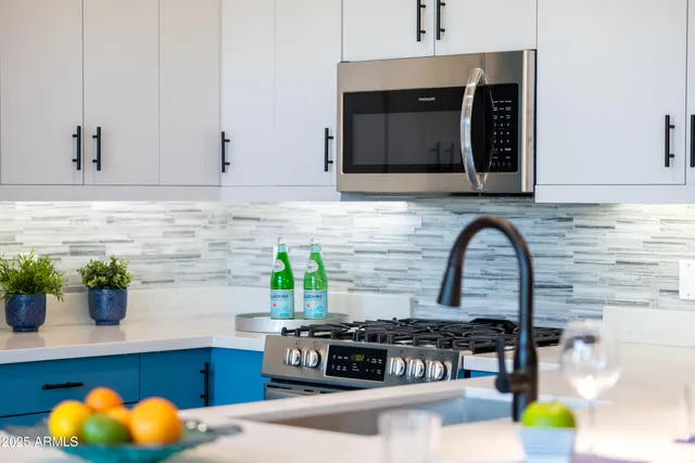 a kitchen with stainless steel appliances granite countertop a sink a refrigerator and a stove