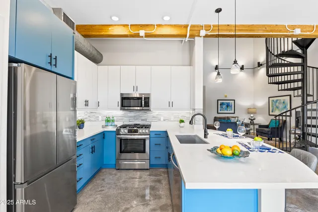 a kitchen with stainless steel appliances a stove a sink and a refrigerator