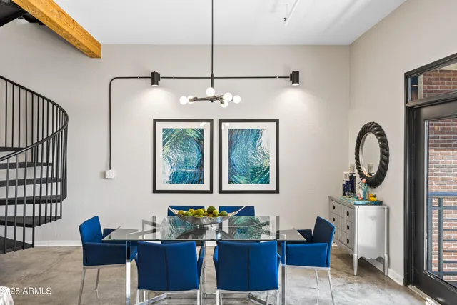 a view of a dining room with furniture a potted plant and wooden floor