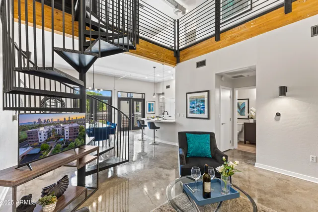 a living room with furniture a chandelier and a dining table