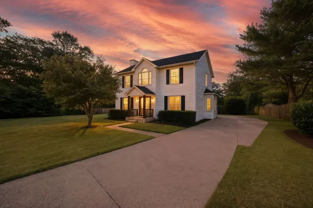 a front view of a house with yard and green space