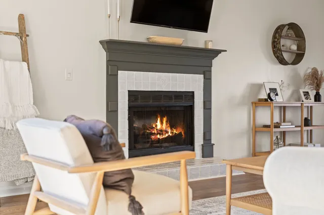 a living room with furniture a flat screen tv and a fireplace