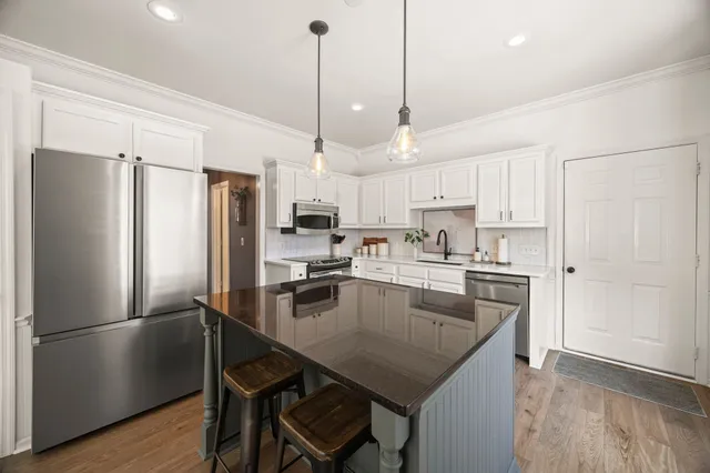 a kitchen with kitchen island a refrigerator a stove a sink and a center island