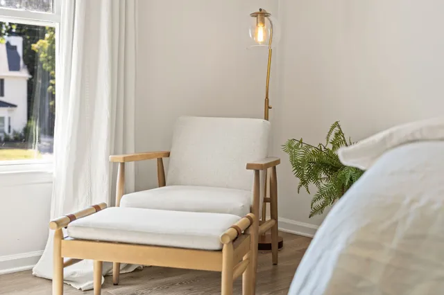 a bedroom with a bed table and chair