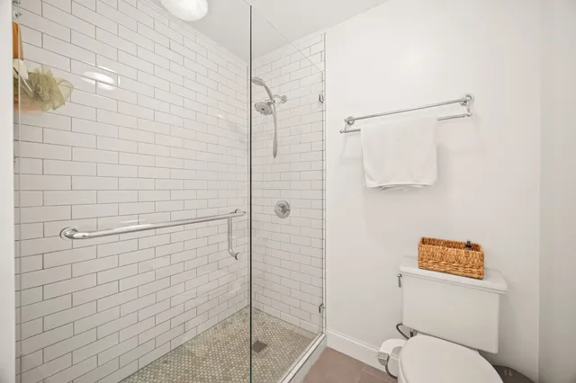 a bathroom with a toilet and a shower