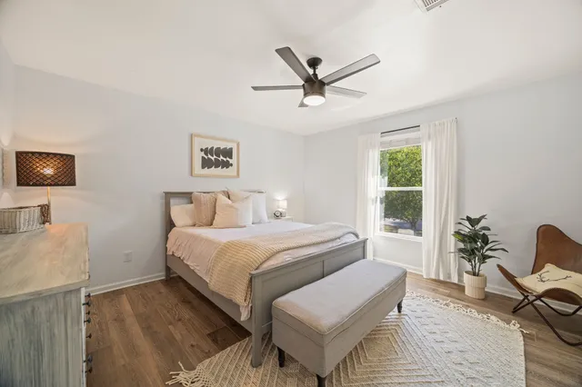 a spacious bedroom with a bed and wooden floor
