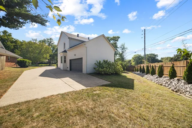 a view of a house with a yard and potted plants