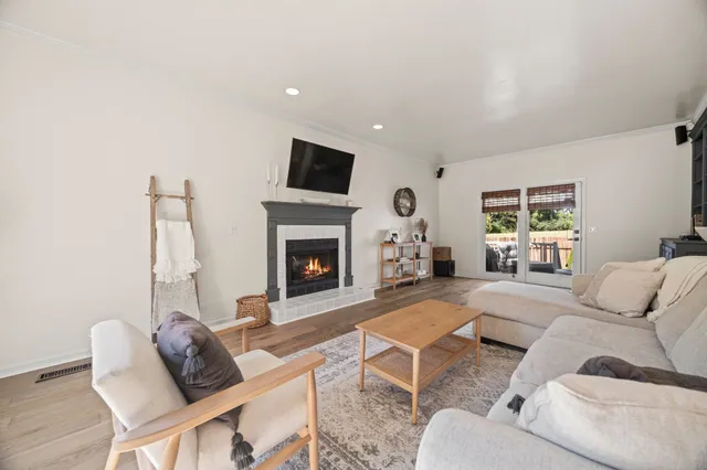 a living room with furniture a flat screen tv and a fireplace