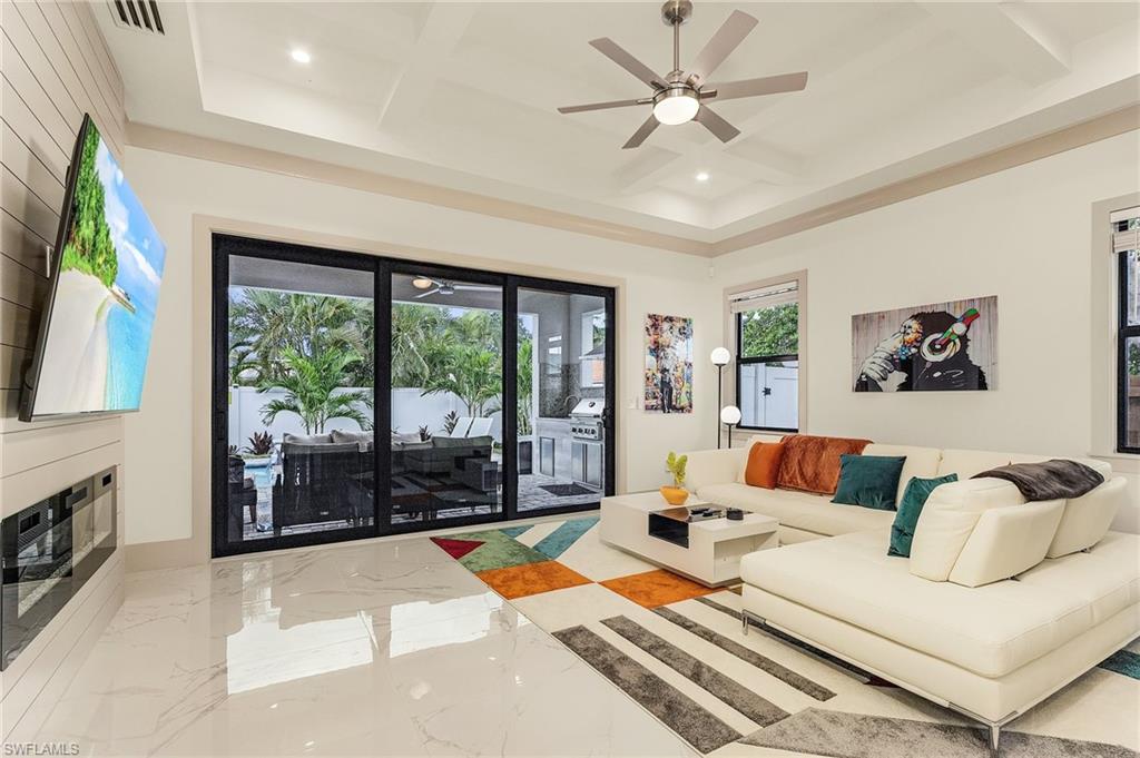 614 105th Avenue North Naples, FL 34108 - Photo 11 of 37 a living room with furniture and a floor to ceiling window