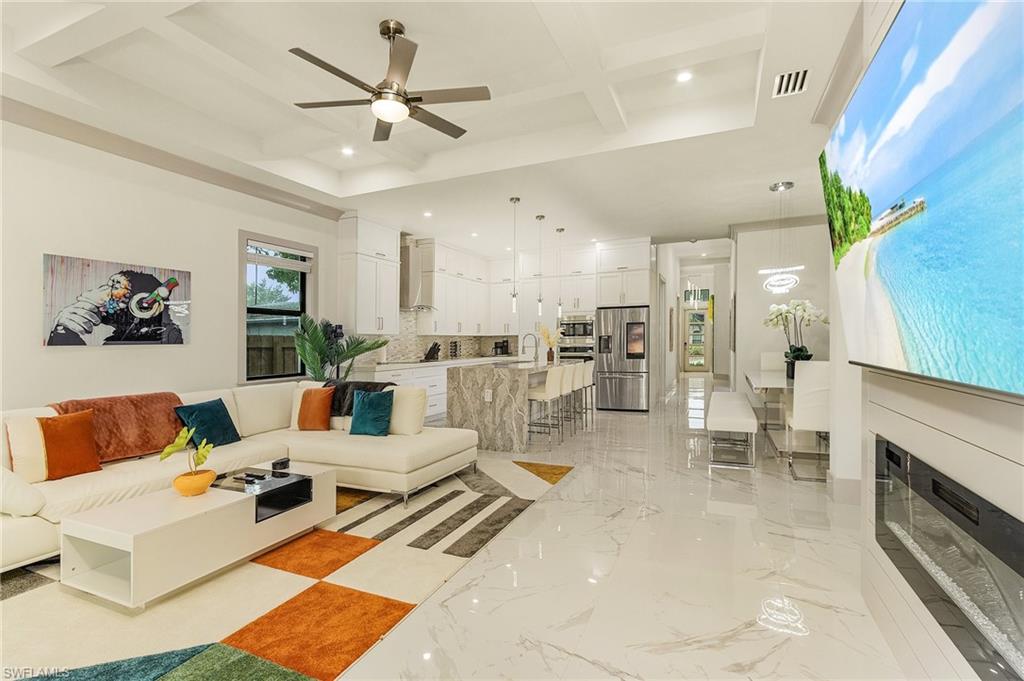 614 105th Avenue North Naples, FL 34108 - Photo 13 of 37 a living room with furniture kitchen view and a chandelier