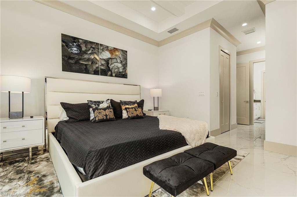 614 105th Avenue North Naples, FL 34108 - Photo 16 of 37 a large bedroom with a bed and wooden floor