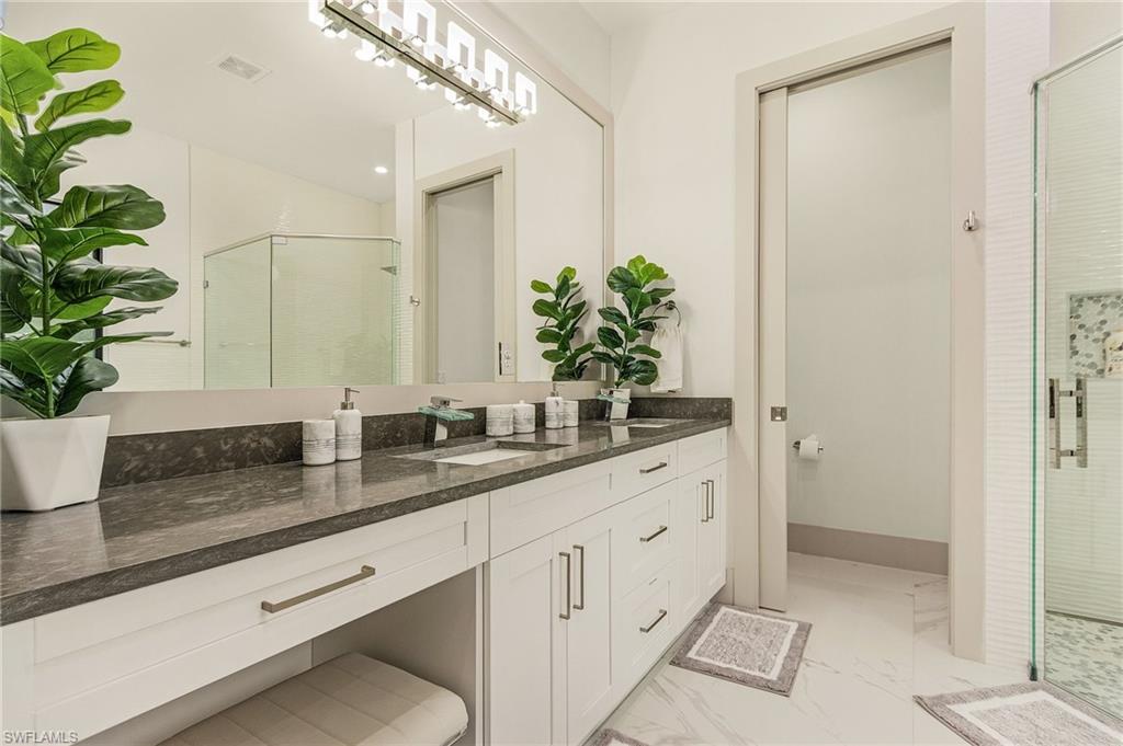 614 105th Avenue North Naples, FL 34108 - Photo 19 of 37 a bathroom with a granite countertop sink a mirror and a potted plant
