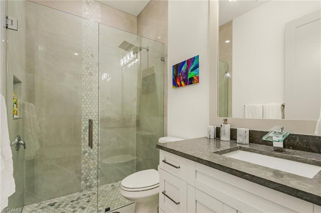 614 105th Avenue North Naples, FL 34108 - Photo 24 of 37 a bathroom with a granite countertop sink a toilet and shower