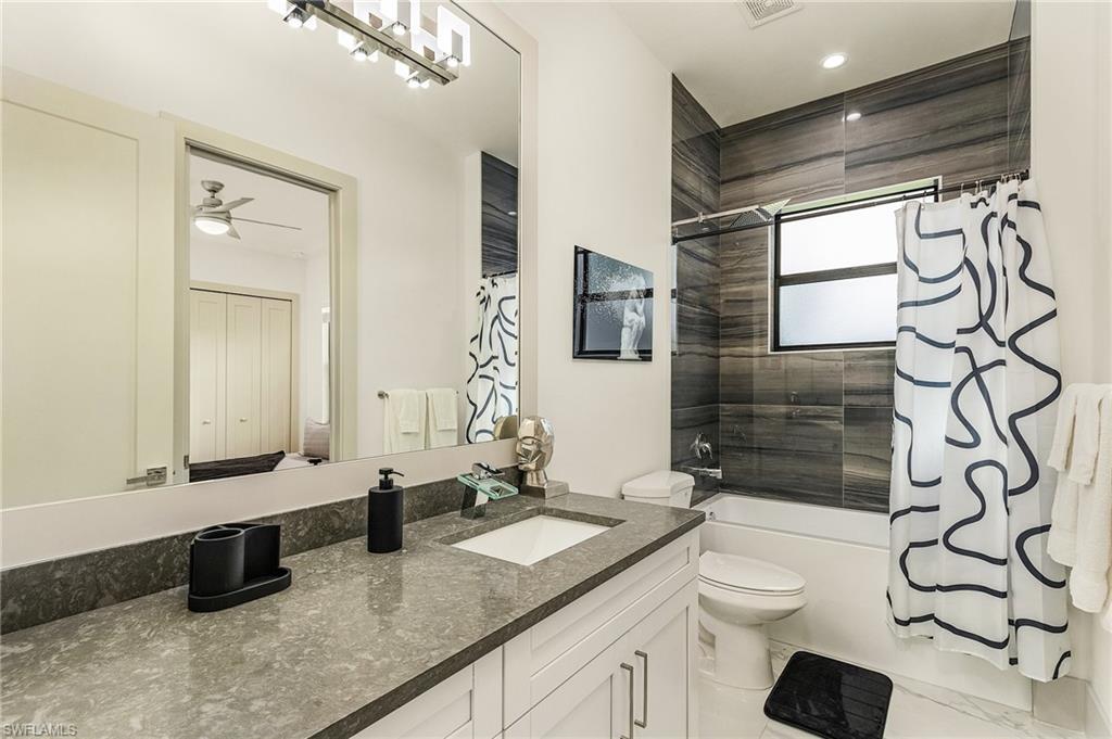614 105th Avenue North Naples, FL 34108 - Photo 25 of 37 a bathroom with a granite countertop sink mirror vanity and toilet