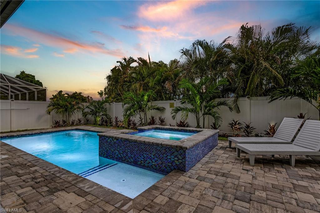 614 105th Avenue North Naples, FL 34108 - Photo 27 of 37 a view of a swimming pool with lounge chair and trees in the background