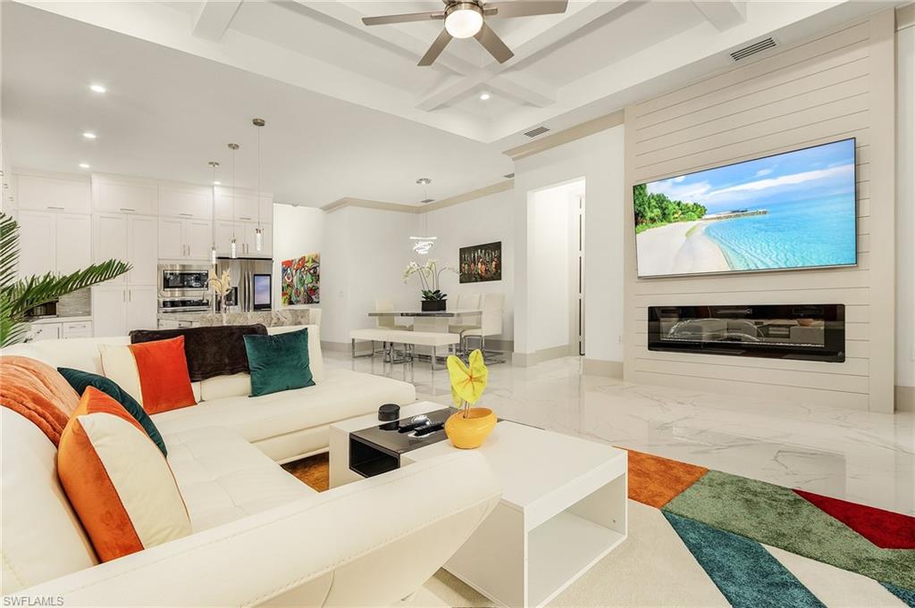 614 105th Avenue North Naples, FL 34108 - Photo 4 of 37 a living room with furniture and a flat screen tv