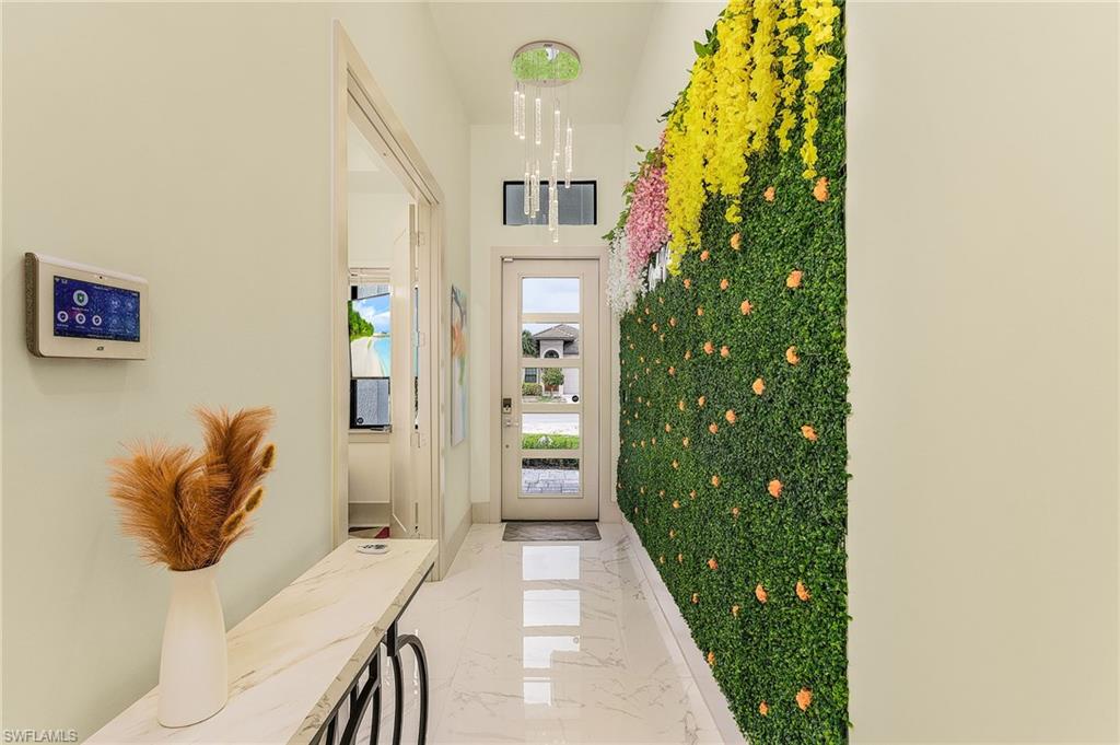 614 105th Avenue North Naples, FL 34108 - Photo 6 of 37 a hallway with painting on the wall and a potted plant