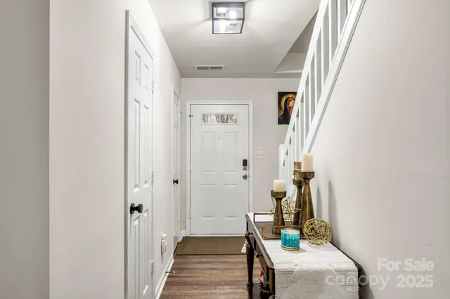 a view of a hallway with wooden floor and stairs