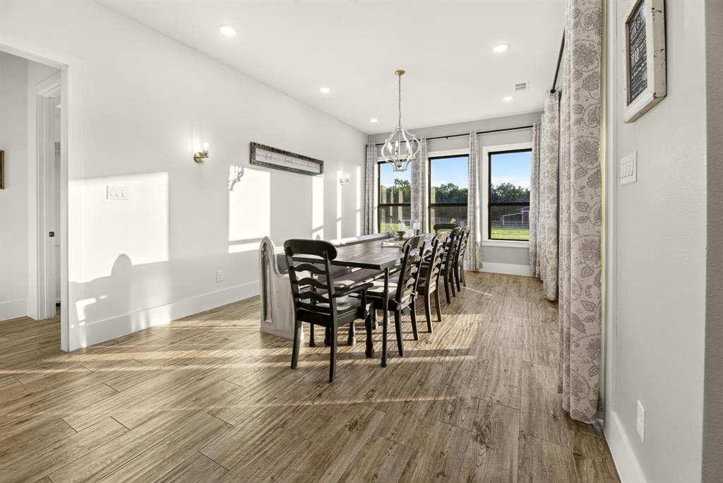 985 Vest Lane Pilot Point, TX 76258 - Photo 17 of 40 Dining area featuring wood-finish flooring, recessed lighting, and wall sconces