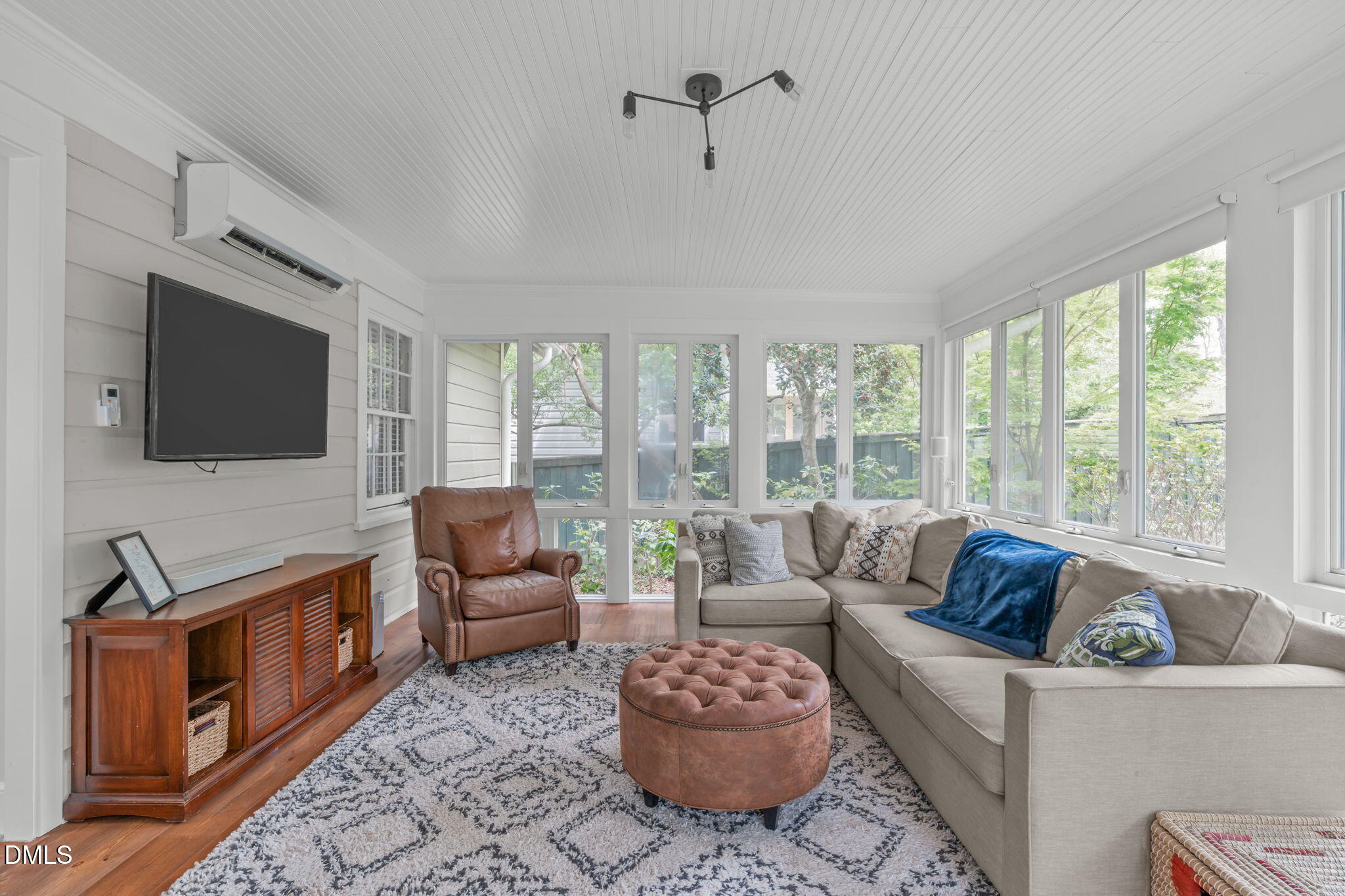 2111 Pershing Street Durham, NC 27705 - Photo 28 of 59 a living room with furniture a flat screen tv and a floor to ceiling window