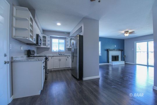 420 Lenore Street Ridgecrest, CA 93555 - Photo 4 of 29 a kitchen with a refrigerator wooden floor and a window