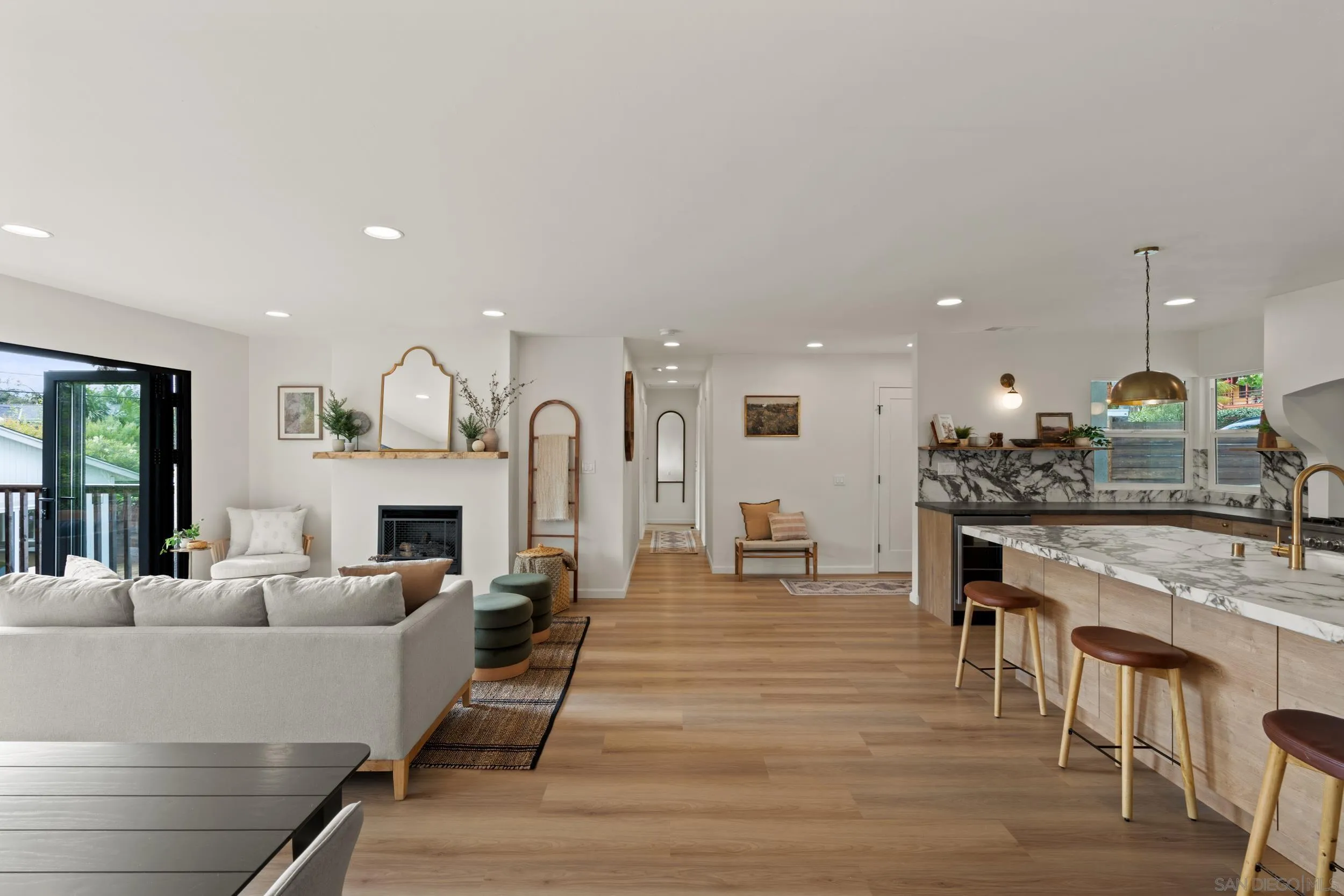 1144 Stratford Drive Encinitas, CA 92024 - Photo 14 of 39 a living room with furniture a fireplace and a kitchen view