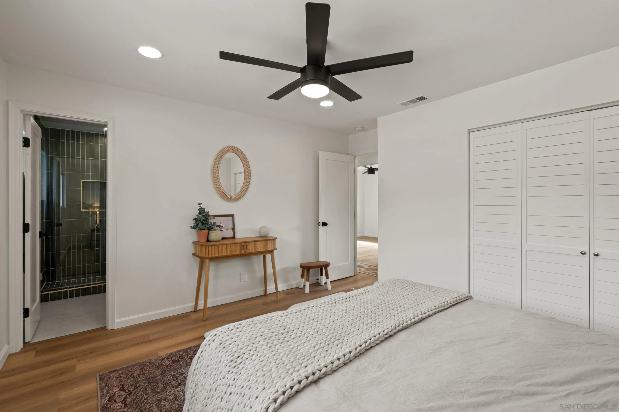 1144 Stratford Drive Encinitas, CA 92024 - Photo 17 of 39 a bedroom with a bed and a chandelier