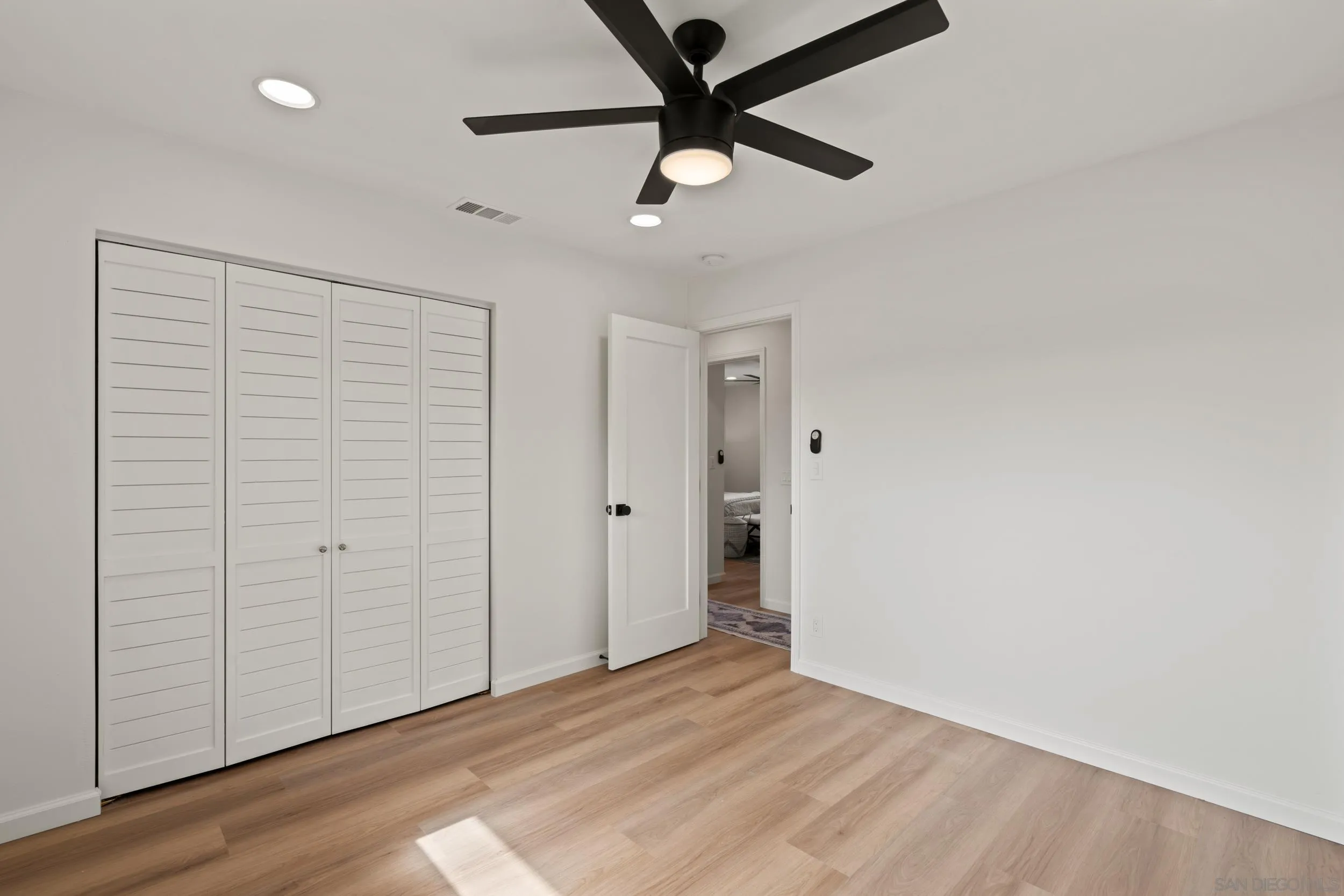 1144 Stratford Drive Encinitas, CA 92024 - Photo 22 of 39 an empty room with wooden floor closet and ceiling fan