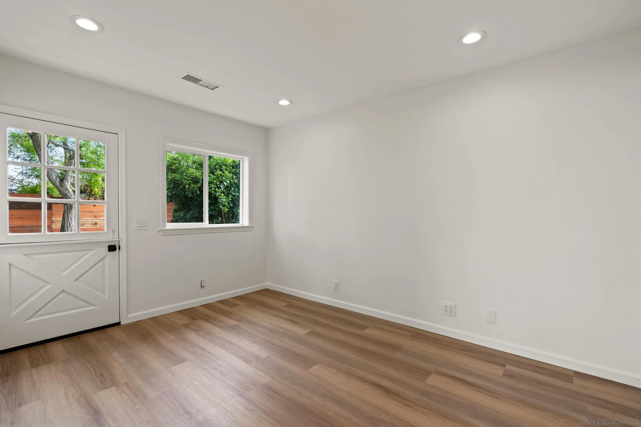 1144 Stratford Drive Encinitas, CA 92024 - Photo 32 of 39 an empty room with wooden floor and windows