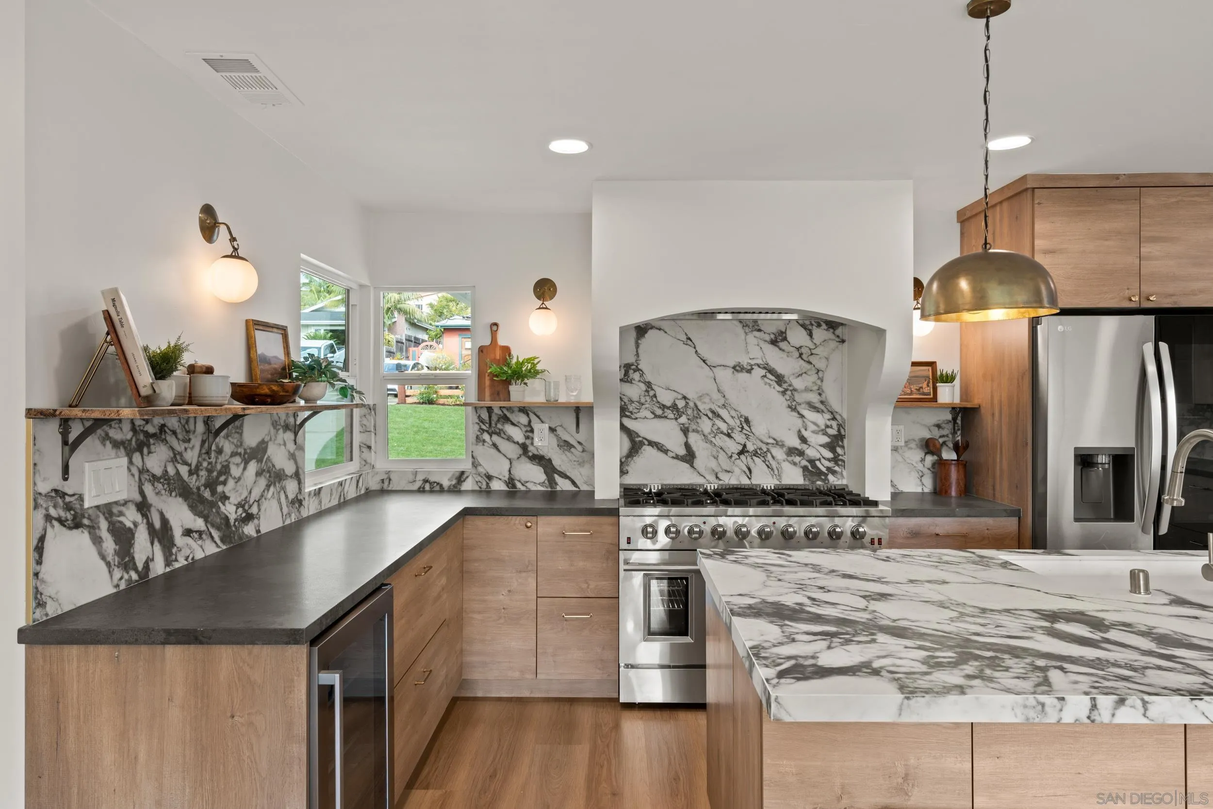 1144 Stratford Drive Encinitas, CA 92024 - Photo 8 of 39 a view of a kitchen with kitchen island a counter top space a sink stainless steel appliances and cabinets