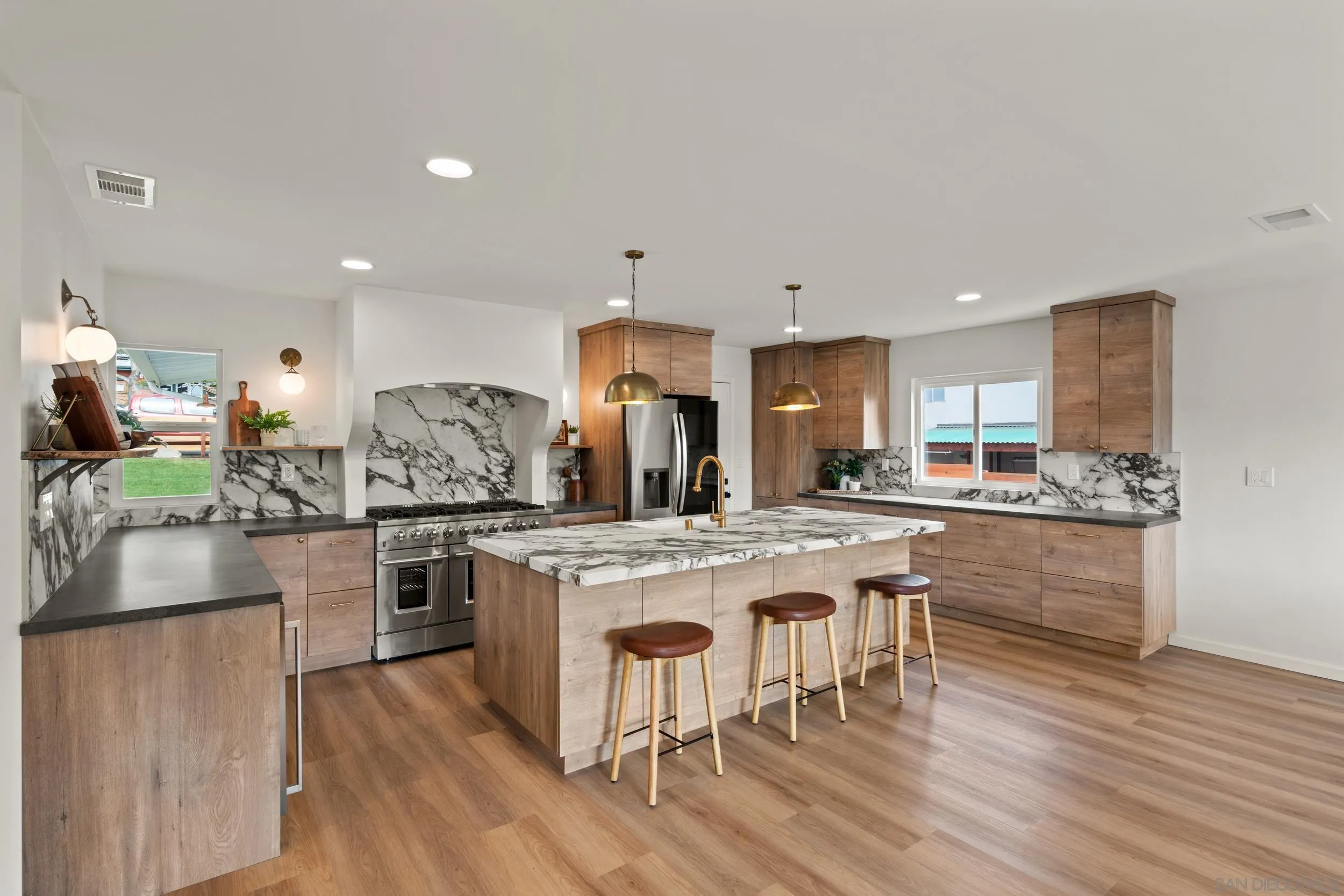 1144 Stratford Drive Encinitas, CA 92024 - Photo 9 of 39 a kitchen with stainless steel appliances granite countertop a table chairs stove and refrigerator