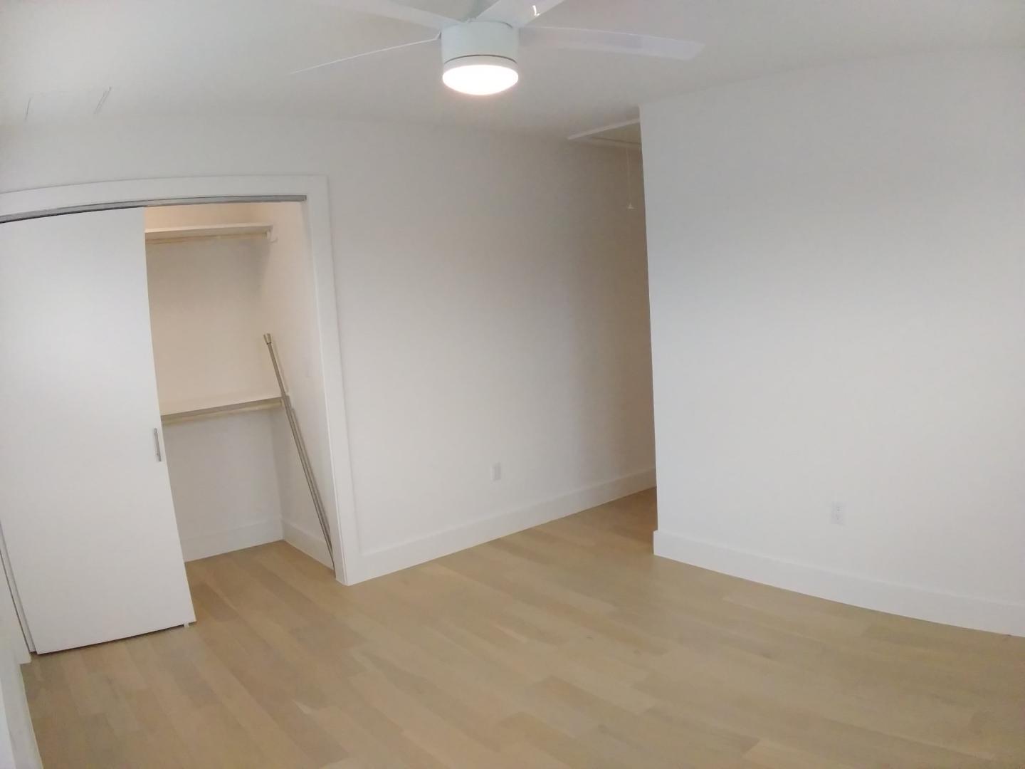 7309 Bennett Avenue, Unit B Austin, TX 78752 - Photo 11 of 16 Unfurnished bedroom with light wood-style flooring, ceiling fan, and a spacious closet