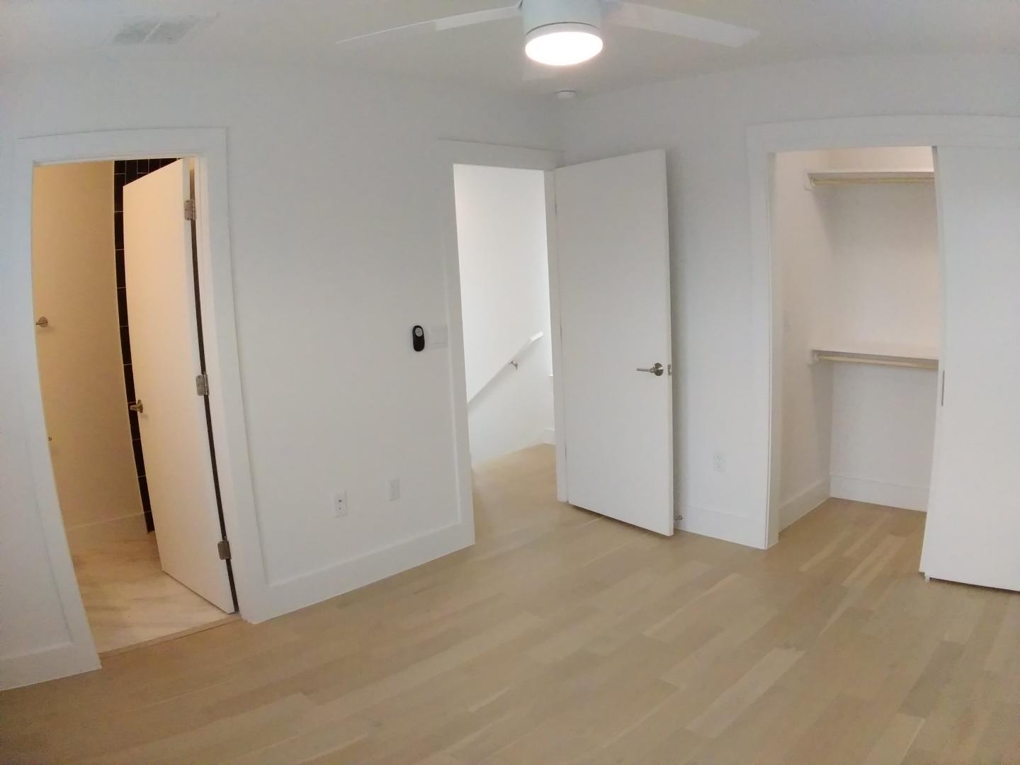 7309 Bennett Avenue, Unit B Austin, TX 78752 - Photo 8 of 16 Unfurnished bedroom with light wood finished floors, ceiling fan, a closet, and ensuite bathroom