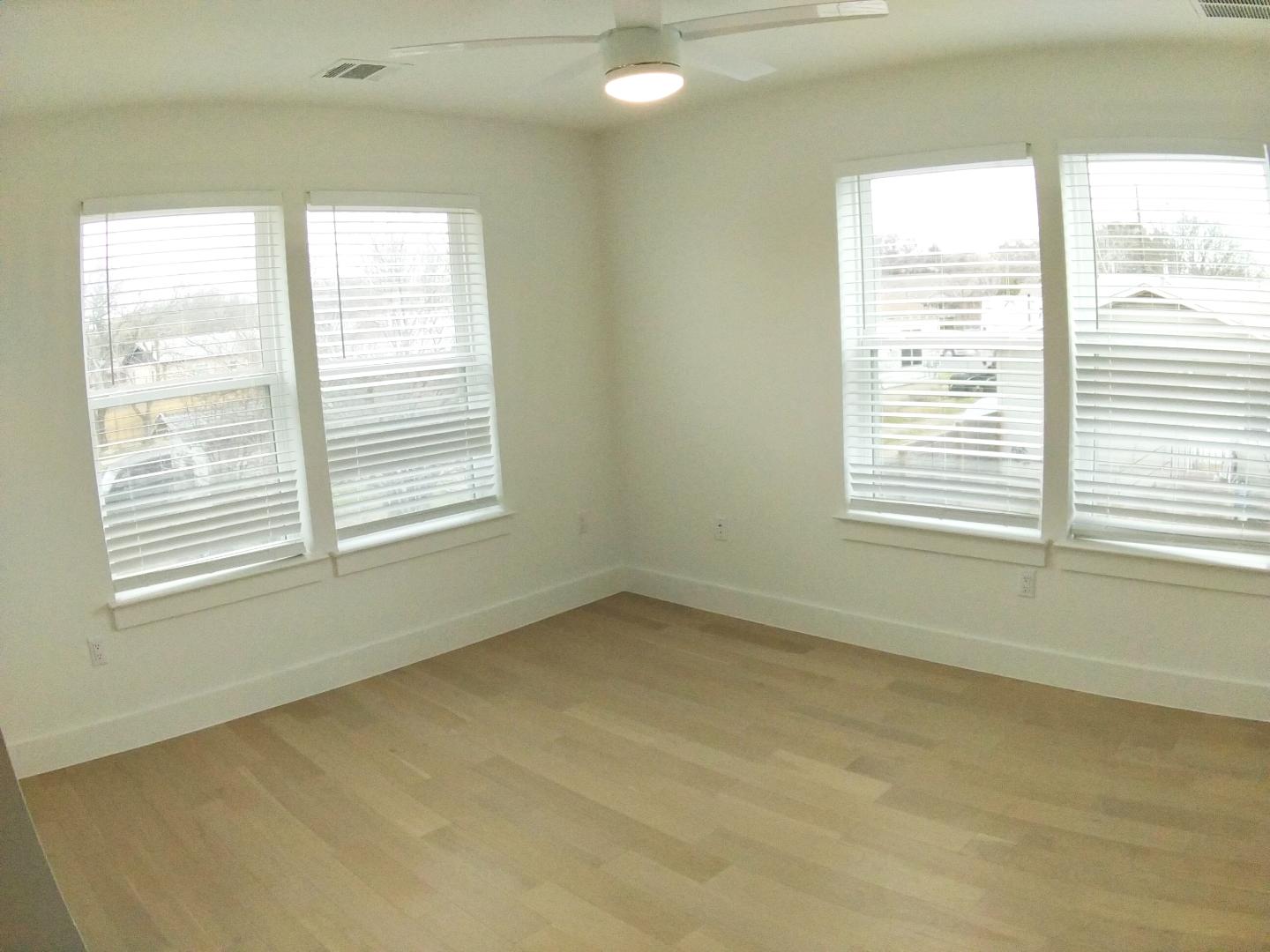 7309 Bennett Avenue, Unit B Austin, TX 78752 - Photo 10 of 16 Empty room featuring a ceiling fan, healthy amount of natural light, and light wood-style floors