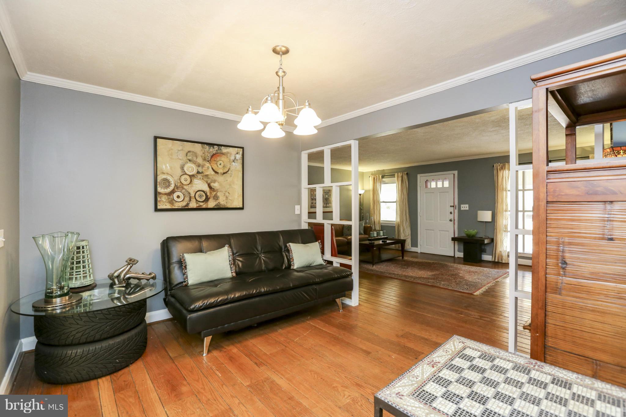 6730 Queens Ferry Road Baltimore, MD 21239 - Photo 7 of 21 a living room with furniture and a chandelier