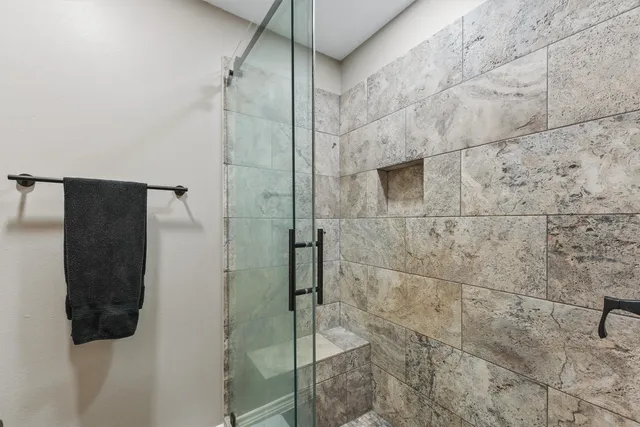 a bathroom with a shower and a glass door