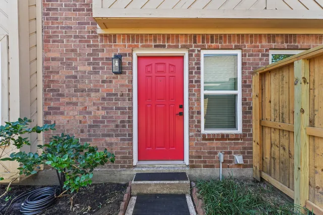 a view of front door of house with potted plants