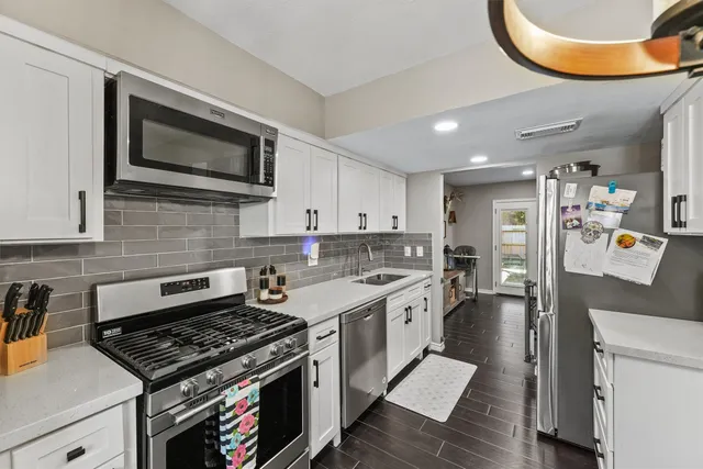 a kitchen with stainless steel appliances granite countertop a stove and a microwave