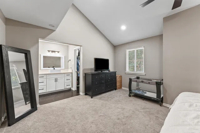 a living room with furniture a flat screen tv and a refrigerator