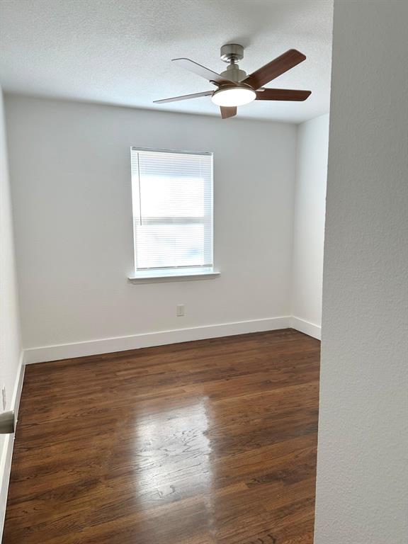 409 Hanbee Street Richardson, TX 75080 - Photo 15 of 18 an empty room with wooden floor chandelier fan and windows