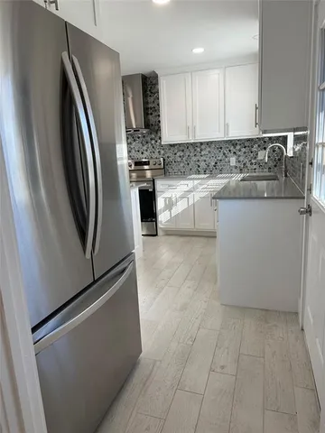 a kitchen with stainless steel appliances granite countertop a refrigerator a stove a sink and a microwave