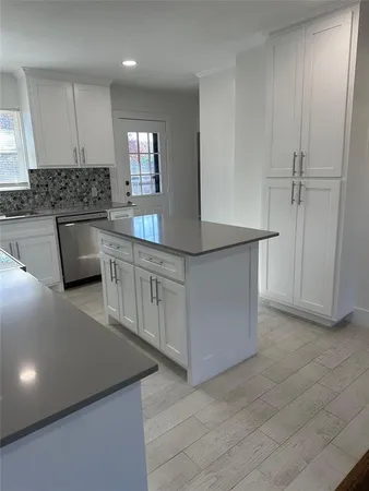 a kitchen with white cabinets appliances and a sink