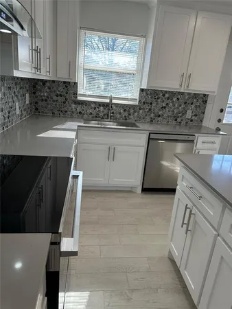 a kitchen with a sink a stove and cabinets