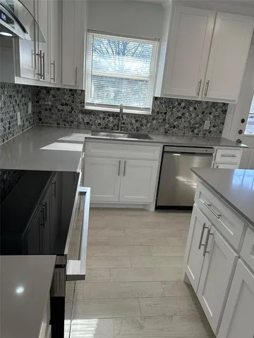 a kitchen with a sink a stove and cabinets