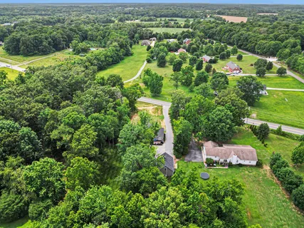 an aerial view of residential houses with outdoor space and trees