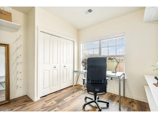 a view of a workspace with furniture and a window